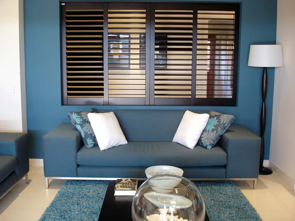 Window shutters on a window in a living room.